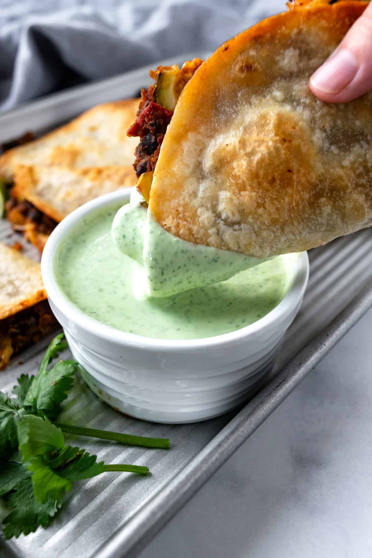 Dipping a Crispy Black Bean Taco in Cilantro Lime Sauce.